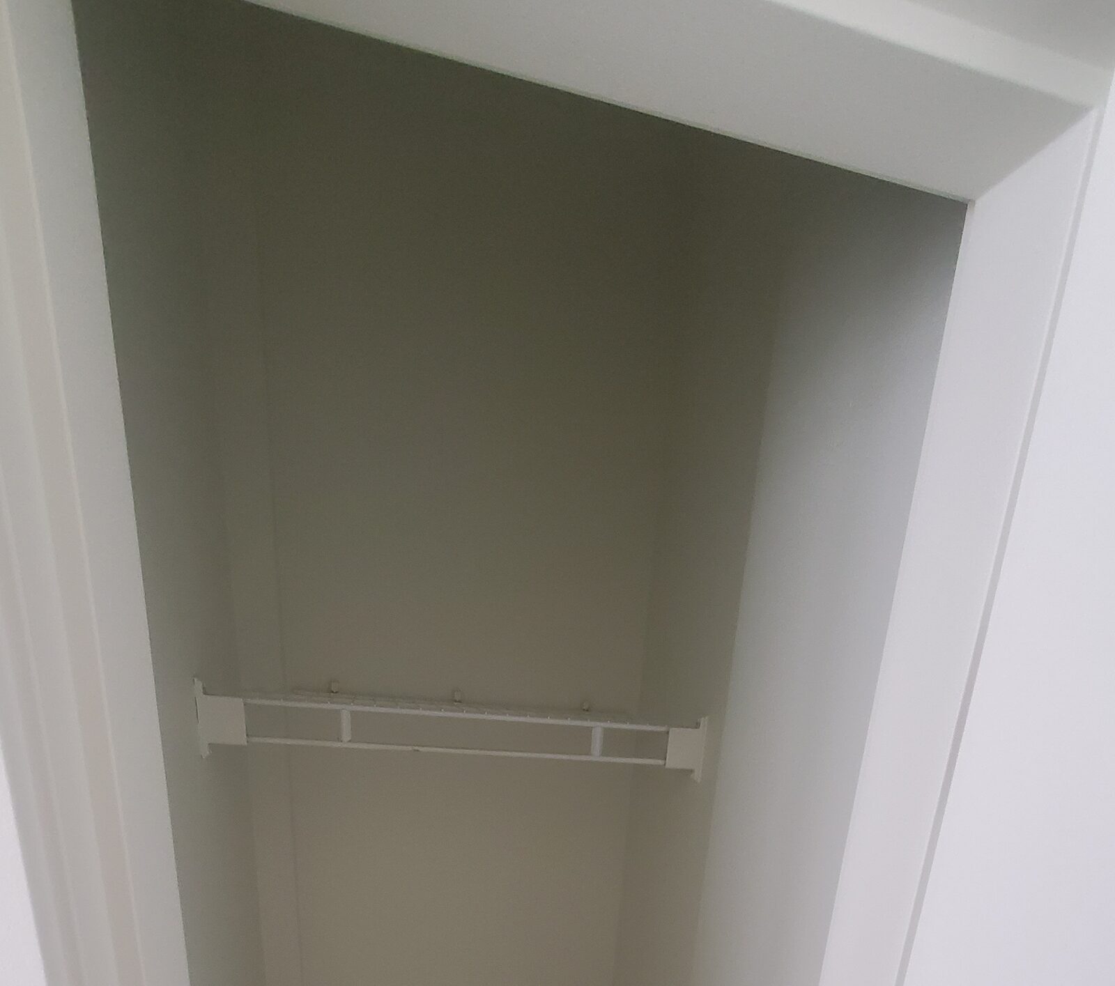 Empty closet with a builder-grade white wire shelf